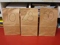 three brown bags with numbers on them sitting on a red table next to some books