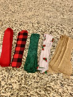 five scarves are lined up on the floor