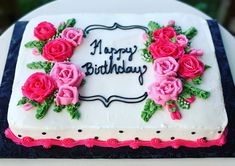 a birthday cake with white frosting and pink roses