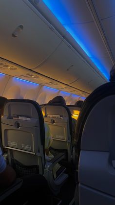 the inside of an airplane with people sitting on seats