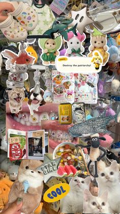 many different stuffed animals are on display in a store window with stickers all over them