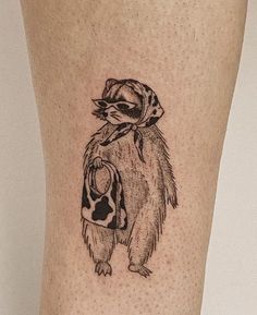 a tattoo on the leg of a woman with a hat and scarf around her neck