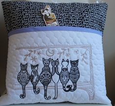 a pillow with three cats on it