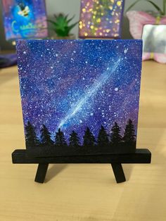 a small card holder with a painting of trees and the stars in the night sky