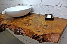 a bowl sitting on top of a wooden table next to a white bowl filled with water