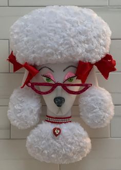 a white teddy bear with red glasses and a poodle on it's head