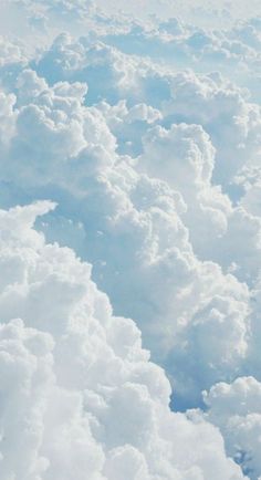 the view from an airplane looking down on some fluffy white clouds and blue sky above