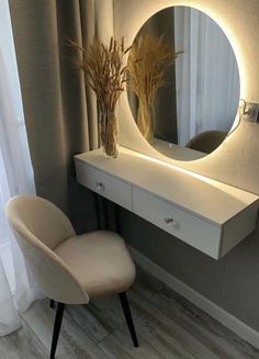 a white chair sitting in front of a mirror on top of a dresser next to a window