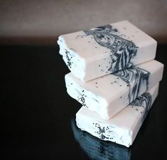 three pieces of white soap sitting on top of a black table next to each other