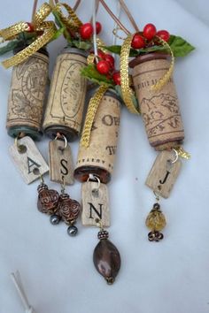 several wine corks with charms attached to them on a white tablecloth next to red berries