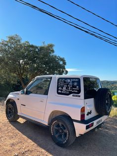 a white truck parked on top of a dirt road