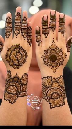 two hands with henna tattoos on them