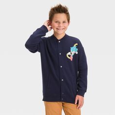 Get your child geared up for the chilly season with this Sonic the Hedgehog Letterman Bomber Jacket. Made of a midweight cotton blend, this long-sleeve jacket sports a full-length snap button front, side welt pockets and ribbed edges for functional flair and a neat look. Sonic's colorful image on the chest and his striking illustration on the back as well as "Sonic" embroidered in yellow and a white label in Japanese, complete the design and take this simple navy blue jacket to the next level. Long Sleeve Cotton Outerwear For School, Playful Winter Fleece Outerwear, Winter School Cotton Outerwear, Playful Fleece Outerwear For Fall, Casual Fleece Outerwear For School, Winter Cotton Outerwear For School, Winter School Fleece Outerwear, Playful Long Sleeve Outerwear With Pockets, Fleece Outerwear For School In Fall