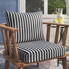 a black and white striped chair sitting on top of a stone floor next to a table