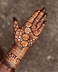 the hand is decorated with henna designs on it's fingers and palm area