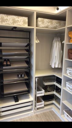 an organized closet with white shelves and drawers