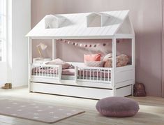 a child's bed with a white roof and pink pillows on the bottom bunk