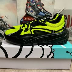 a pair of black and yellow sneakers on top of a box