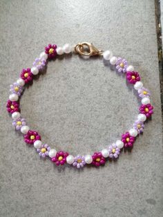 a bracelet with flowers and pearls is shown on the floor in front of a door