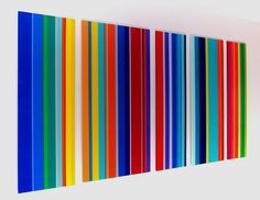 an abstract art piece with multicolored lines on the wall in front of it