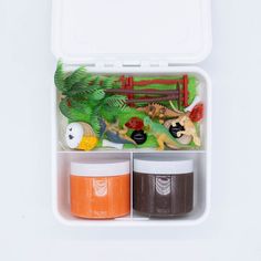 an open lunch box filled with different types of toys and food in it's storage compartment