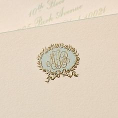 the monogrammed wedding stationery is displayed on an envelope