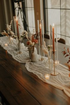 a long table with candles and flowers on it