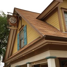 a yellow and brown house with blue shutters