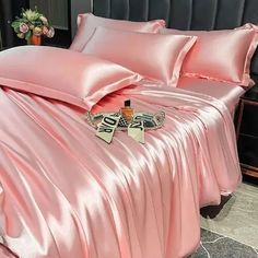 a bed covered in pink sheets and pillows