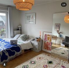 a bed room with a laptop on top of it next to a window and a rug