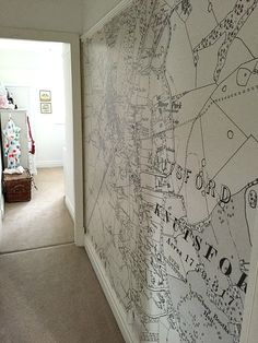 a hallway with a large map on the wall and carpeted flooring in front of it