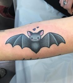 a small bat tattoo on the arm