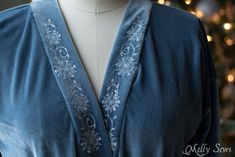 a close up of a mannequin wearing a blue dress with white flowers on it