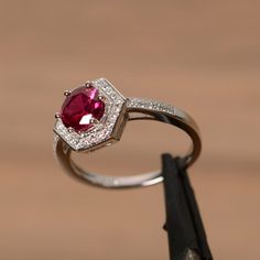 It is a lab ruby ring. The main stone is 7mm round cut, weight about 1.65 carats. The basic metal is sterling silver and plated with rhodium. To change the metal to a solid gold (white/rose) or platinum is also available, please ask for a quotation if you want. You can also go to my shop Home for more elegant rings: https://www.etsy.com/shop/godjewelry?ref=hdr_shop_menu Ruby is the birthstone of July, it will be a great gift for your lover! More ruby rings: https://www.etsy.com/shop/godjewelry?r Ruby Halo Ring For Promise Occasion, Ruby Halo Promise Ring, Lab-created Ruby Halo Ring For Promise, White Gold Ruby Halo Ring, White Gold Halo Ring With Ruby, Fine Jewelry Ruby Birthstone Ring With Halo Setting, Ruby Birthstone Ring With Halo Setting, Fine Jewelry, Lab-created Ruby Ring With Halo Design, Classic Ruby Birthstone Ring With Halo Setting