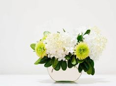 a vase filled with white and green flowers