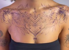 a woman with tattoos on her chest and back