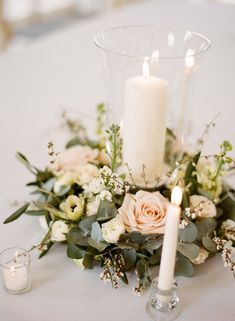 a table topped with a vase filled with flowers and candles