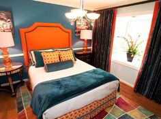 a bedroom with blue walls and orange headboard