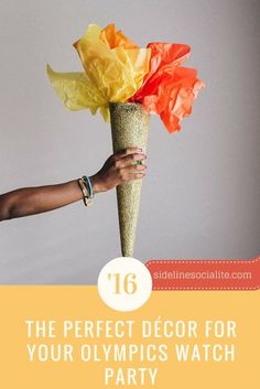 a person holding a vase with flowers in it and the words 16 the perfect decor for your olympics watch party