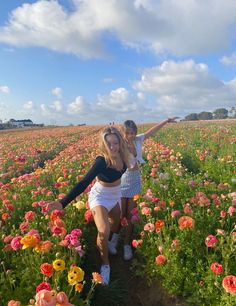 two women standing in a field full of flowers