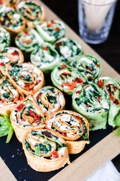 several rolls with spinach and cheese on a cutting board