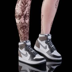 the legs and ankles of a person with tattoos on them, wearing nike air force sneakers