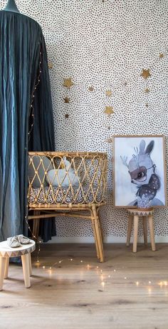 a baby crib in front of a wallpapered room with gold foil stars