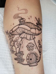 a mushroom house tattoo on the leg with an insect crawling out of it's hole