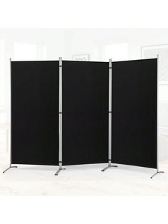 three black screens are standing in front of a white wall and one is open to reveal the