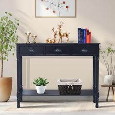 a black console table with two drawers and a basket under it next to a potted plant