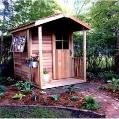 a small wooden shed in the middle of a garden