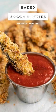 baked zucchini fries in a small metal bowl with dipping sauce on the side