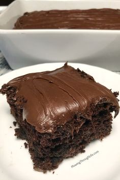 a piece of chocolate cake sitting on top of a white plate next to a bowl