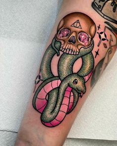 a person with a skull and snake tattoo on their arm